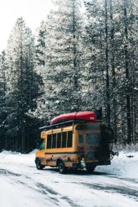 un autobus scolaire jaune roulant sur une route enneigée