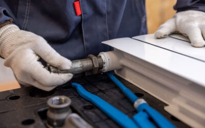 Plombier chauffagiste installant un raccord de radiateur avec précision lors d'une intervention à Toulouse