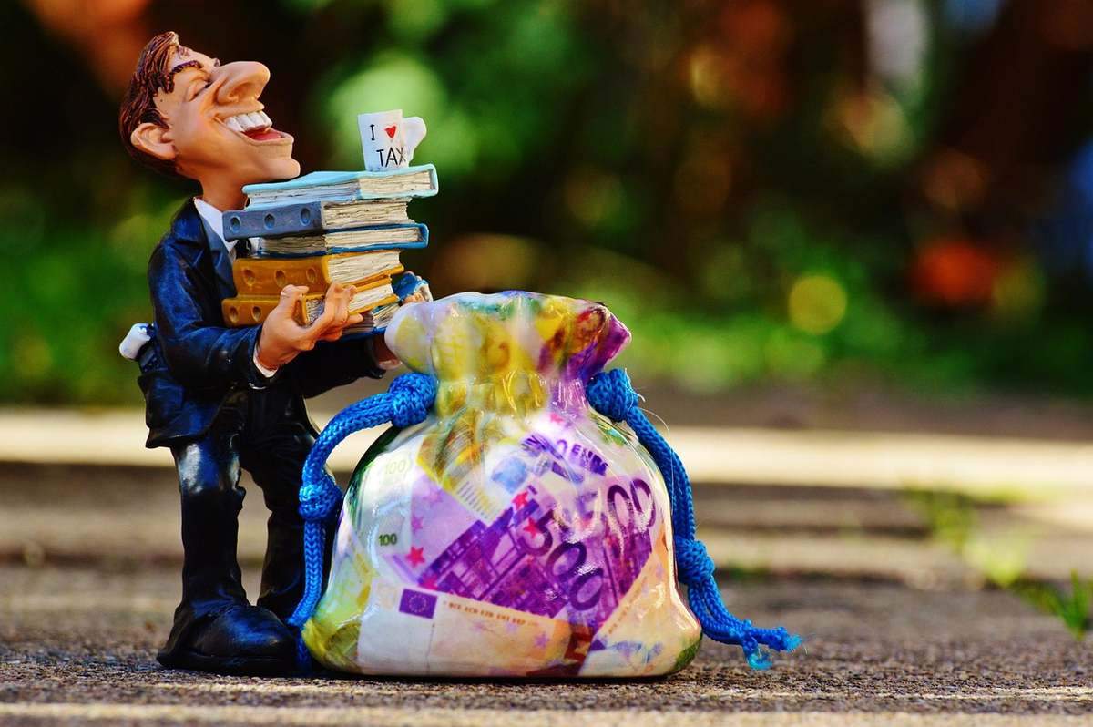 Figurine d'homme avec un sac d'argent et des livres, trottoir Figurine d'homme avec un sac d'argent et des livres, trottoir