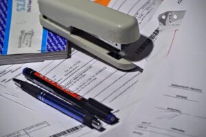 Stylos sur documents avec agrafeuse et classeur sur bureau