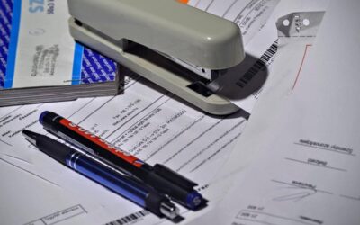 Stylos sur documents avec agrafeuse et classeur sur bureau