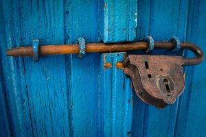 cadenas rouillé sur porte bleue, barre de fer, serrure fermée