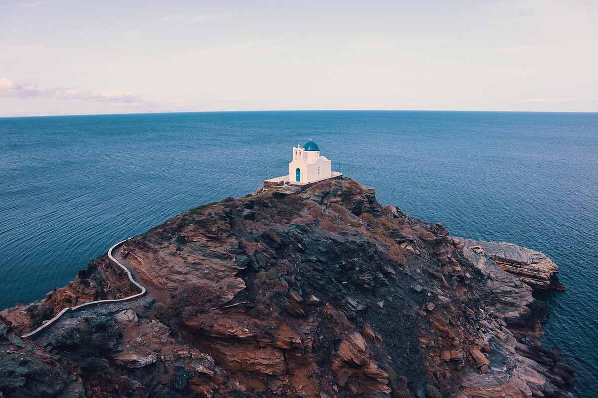 Chapelle blanche sur îlot rocheux au milieu de la mer