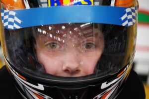 Enfant équipé d'un casque de karting bleu blanc noir avec visière teintée