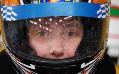 Enfant équipé d'un casque de karting bleu blanc noir avec visière teintée