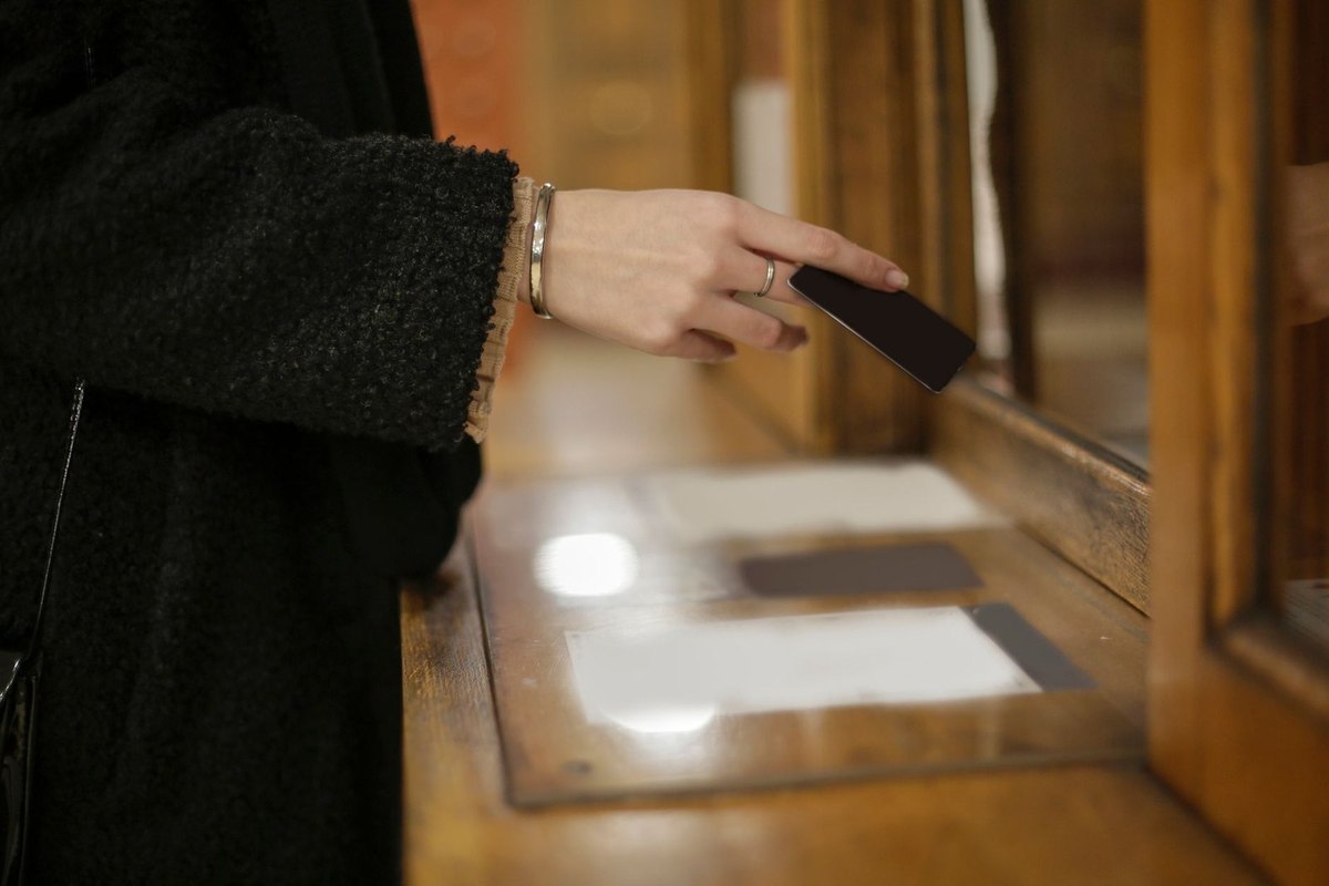 Femme écrivant sur un document avec un stylo à la main, dans un bureau en bois