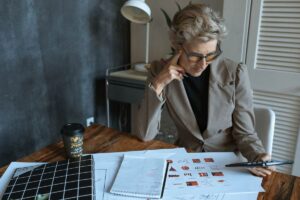 Une femme en costume examine des plans sur un bureau