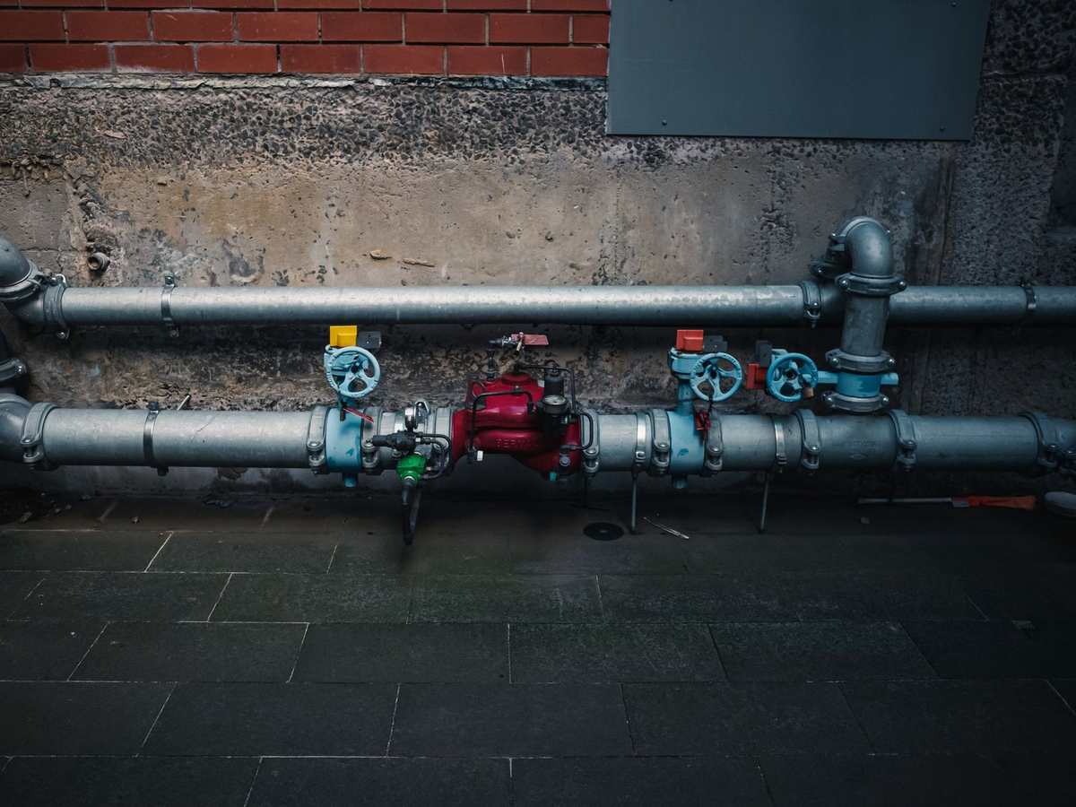 Industrial pipes with valves and gauges installed on a concrete wall